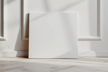 Art canvas in a horizontal position on the floor leaning against a white wall. Clean cloth for mockup art presentation