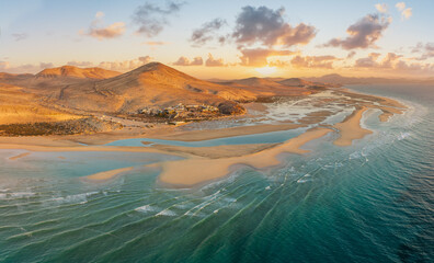 Playa de Sotavento at sunrise, Fuerteventura: a breathtaking aerial view of crystal-clear lagoons and sweeping sand dunes on this iconic Canary beach.