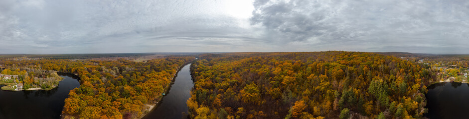 Fototapeta premium Autumn aerial wide panorama of river valley and colorful golden forest. Autumnal vibrant trees in rural riverside in Ukraine