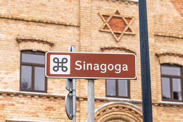Obraz premium Old brick Synagogue, Jewish shul or temple with road signpost and David star on the facade in Alytus, Lithuania 