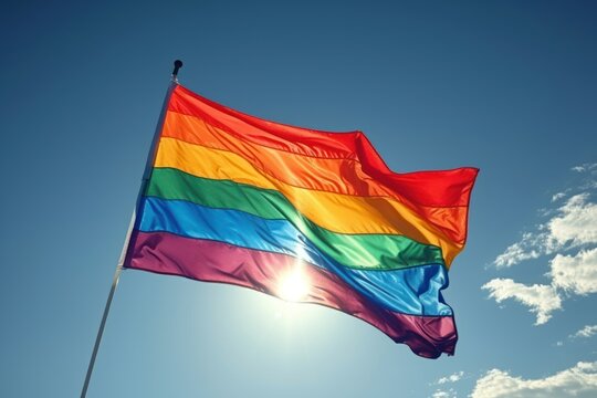 Bright LGBT flag fluttering against blue sky, space for text. Lesbian concept