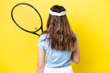 Young caucasian woman isolated on yellow background playing tennis