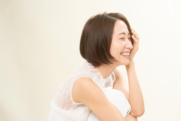 Obraz na płótnie Canvas ミドル世代日本人女性ビューティー／髪を触りながら笑っている