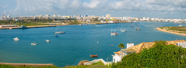 View of the Arade river and the city of Portimão from the historical fishing village of Ferragudo,...