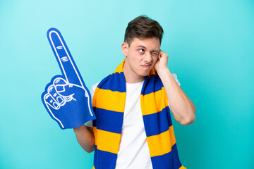 Young sports fan man isolated on blue background frustrated and covering ears