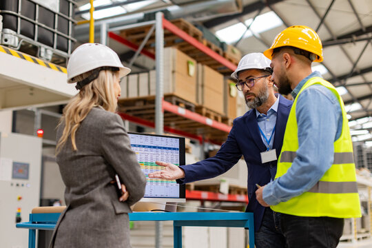 Engineer, foreman consulting with director in modern industrial factory, talking about new production project or investment. Team management in manufacturing facility.