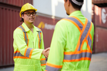 workers or engineers shaking hands before starting to work in containers warehouse storage
