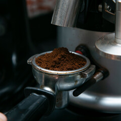 Professional barista working with a coffee machine and preparing hot drinks with coffee and milk.