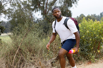 Close Up Photo of  Wandering Black African American Holding a Yellow Tumbler While Hiking in Rocky Mountain during Daylight