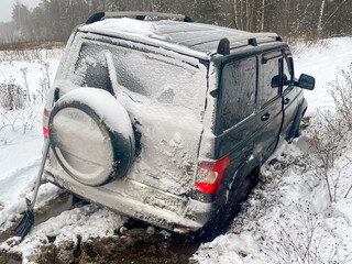 A 4x4 SUV stuck in mud and snow. Problems of car ownership in winter. The concept of adventure...
