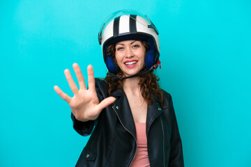 Young caucasian woman with a motorcycle helmet isolated on blue background counting five with fingers