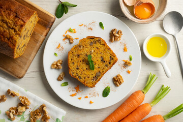 Delicious and fluffy carrot cake with walnuts on a wooden board.