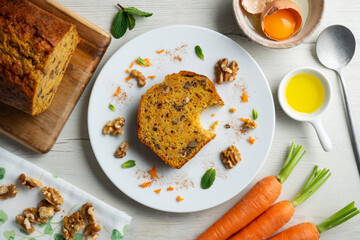 Delicious and fluffy carrot cake with walnuts on a wooden board.