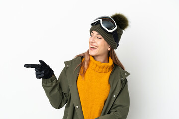 Skier caucasian woman with snowboarding glasses isolated on white background pointing finger to the...