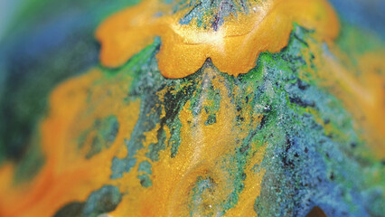 Glitter fluid background. Ink flow. Sparkling mix. Yellow color shimmering paint stream motion green black blue blend on surface in abstract captivating fantasy art.