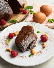 Delicious and fluffy round chocolate cake with cashews and raspberries.