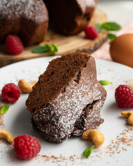 Delicious and fluffy round chocolate cake with cashews and raspberries.