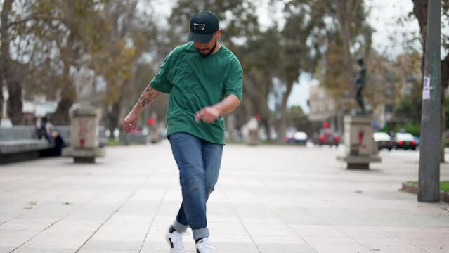  breakdancer guy performing floor based footwork on the street