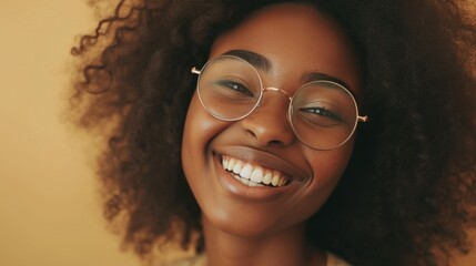 Smiling woman with curly hair and round glasses.