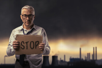 Businessman holding a sign and polluted environment