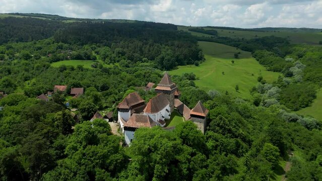 Beautiful and traditional Viscri Village. Viscri is only one of the Saxon villages of Transylvania. View of his main attractions, The Fortified Church and cemetery. Drone spinning around the church.
