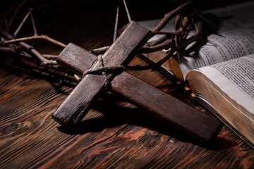 Christian cross with crown thorns on dark background.