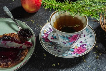 Christmas mood - spruce branch. Pancakes with jam - food and drink on a dark background
