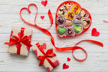 Valentine day composition: sweet candy, with gift boxes with bow and red felt hearts, photo template, background. Top View with copy space