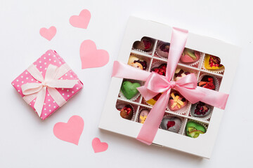 Valentine day composition: sweet candy, with gift boxes with bow and red felt hearts, photo template, background. Top View with copy space