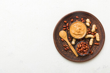 Fototapeta na wymiar Bowl of peanut butter and peanuts on table background. top view with copy space. Creamy peanut pasta in small bowl