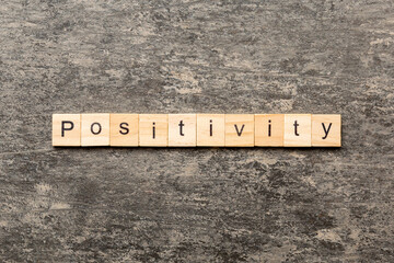 positivity word written on wood block. positivity text on cement table for your desing, concept