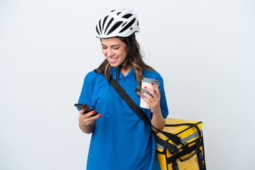 Young delivery woman with thermal backpack isolated on white background holding coffee to take away and a mobile