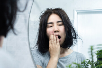 excessive yawning concept with fatigued Asian woman feeling tired and yawn all the time, medical...