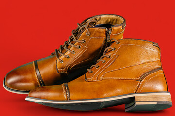 A pair of premium calfskin boots on a red background. Horizontal shot.