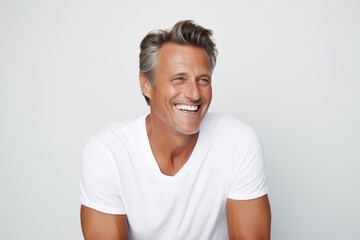 Portrait of happy mature man in white t-shirt smiling and looking at camera