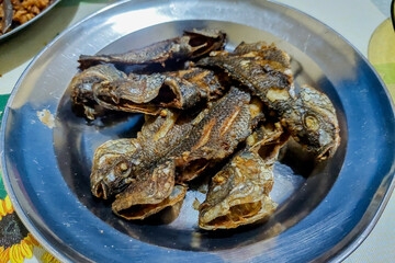 fried fish on a plate on the dining table