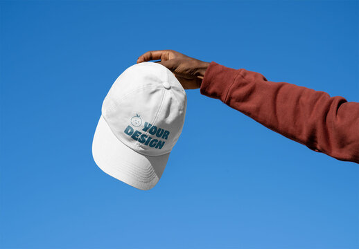 Mockup of man holding customizable baseball cap