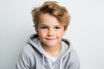 Portrait of a cute smiling little boy in a gray hoodie.