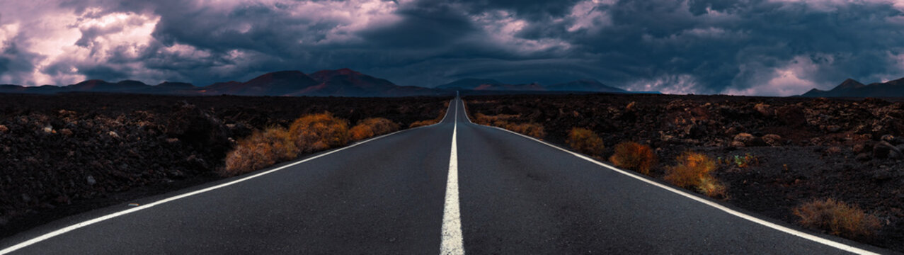 Imagen relacionada con viajes por carretera y aventuras por descubrir. Carretera a través del paisaje escénico hasta el destino en el parque natural de Lanzarote. Parque natural de Timanfaya