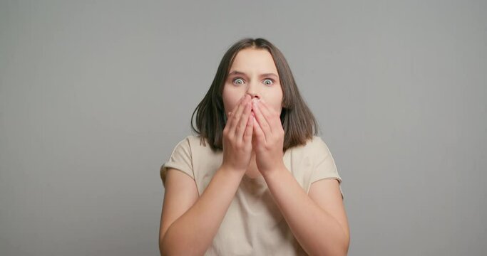 Image of shocked anxious latin teenager girl in panic, holding hands on head and worrying, standing frustrated and scared against grey background