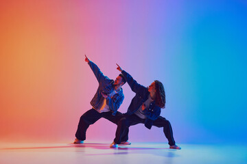 Dynamic shot of young, athletic male and female dancers dressed in modern urban denim outfits...