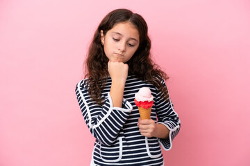 Little caucasian girl holding an ice cream isolated on pink background having doubts