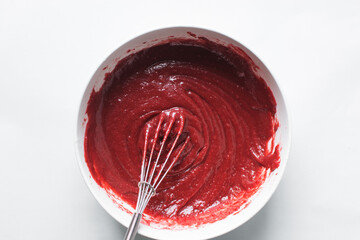 Top view of Red velvet cake batter in a white ceramic mixing bowl