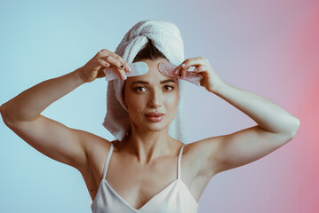 A young woman massaging her face with guasha scrubbers. Facial skin care. Healthy, glowing skin