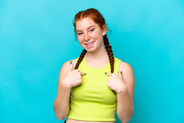 Young reddish woman isolated on blue background with surprise facial expression