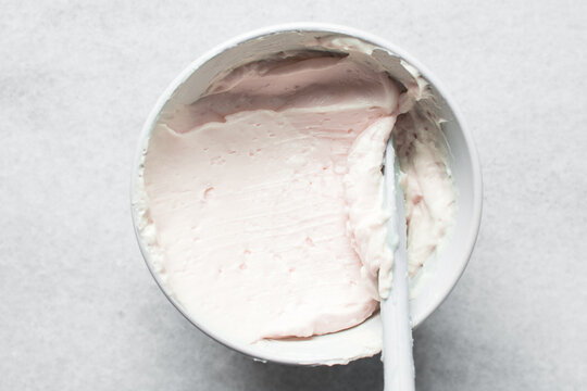 pink buttercream in a white mixing bowl, American buttercream in a bowl for icing cake, frosting for decorating cake