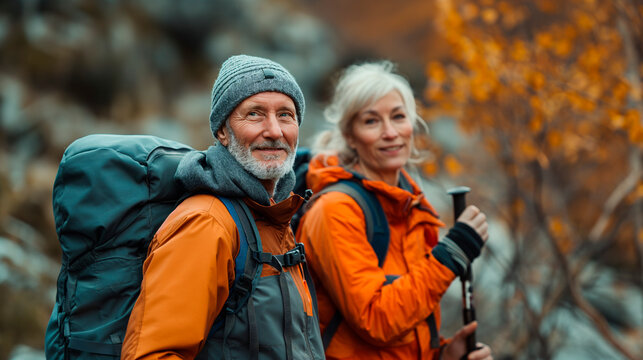 Pareja de  50 a&ntilde;os andando por la monta&ntilde;a con ropa de monta&ntilde;ero, mochila y gorro