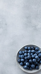 Fresh Blueberries in Ceramic Bowl on Textured Grey Background