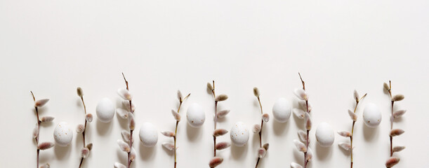 Easter composition with a willow branch and white quail eggs on a light gray background. Springtime...