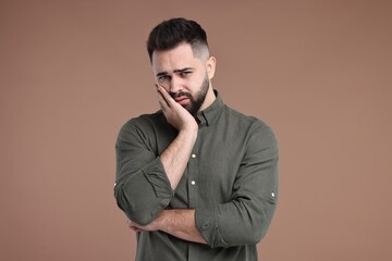 Portrait of sad man on brown background
